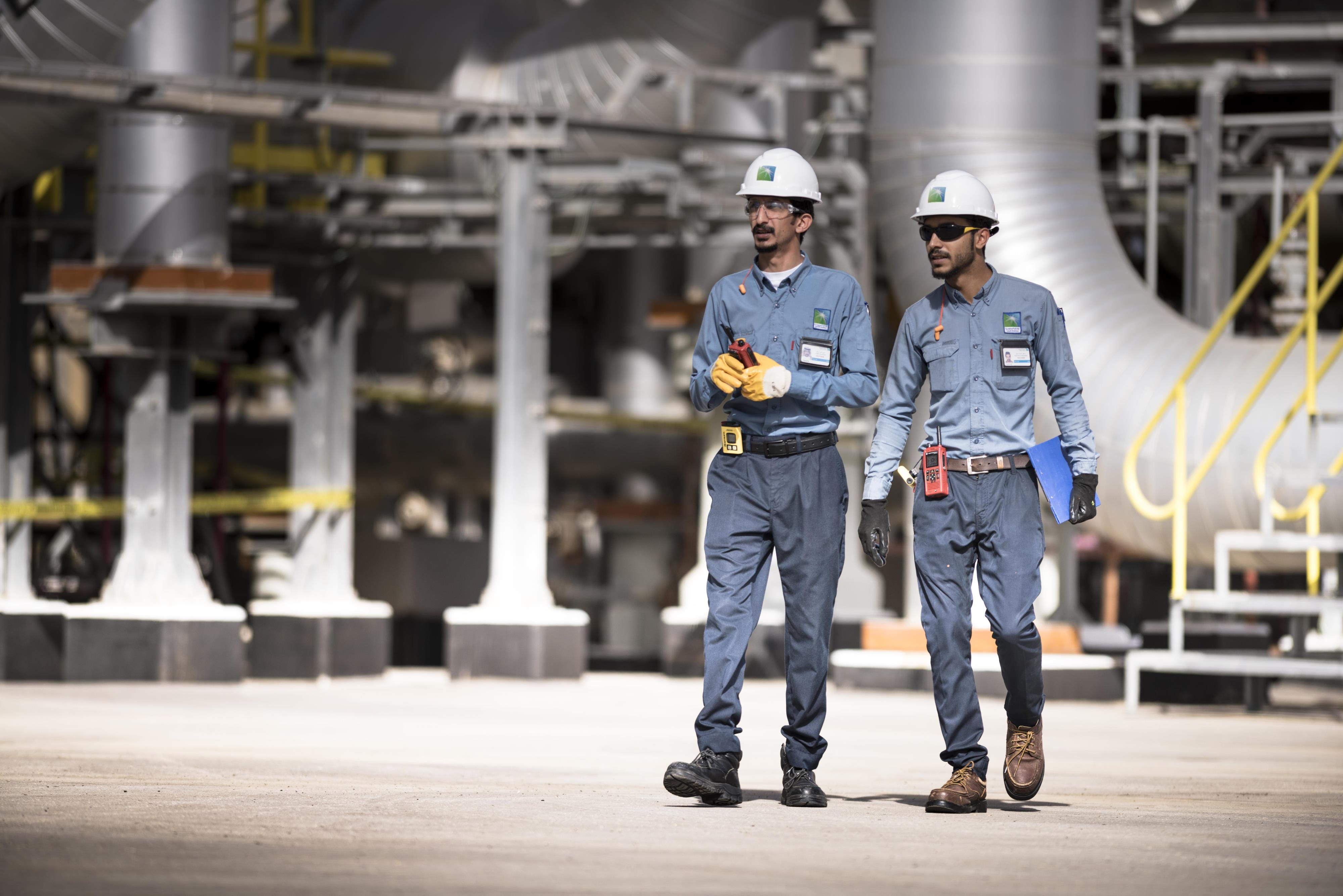 Two Saudi Aramco engineers walking around at production plant